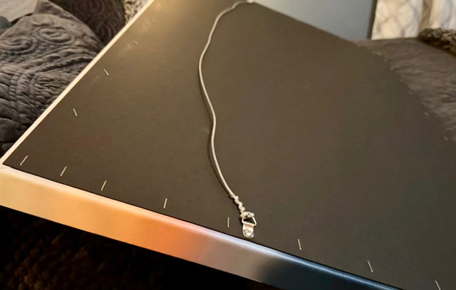 Close up of the back of a canvas print showing gallery wrapped edges, stapled hardback, and wire hanger.
