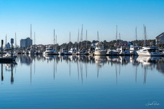 Carolina Beach Marina in North Carolina with boats docked along the waterfront under bright blue skies.